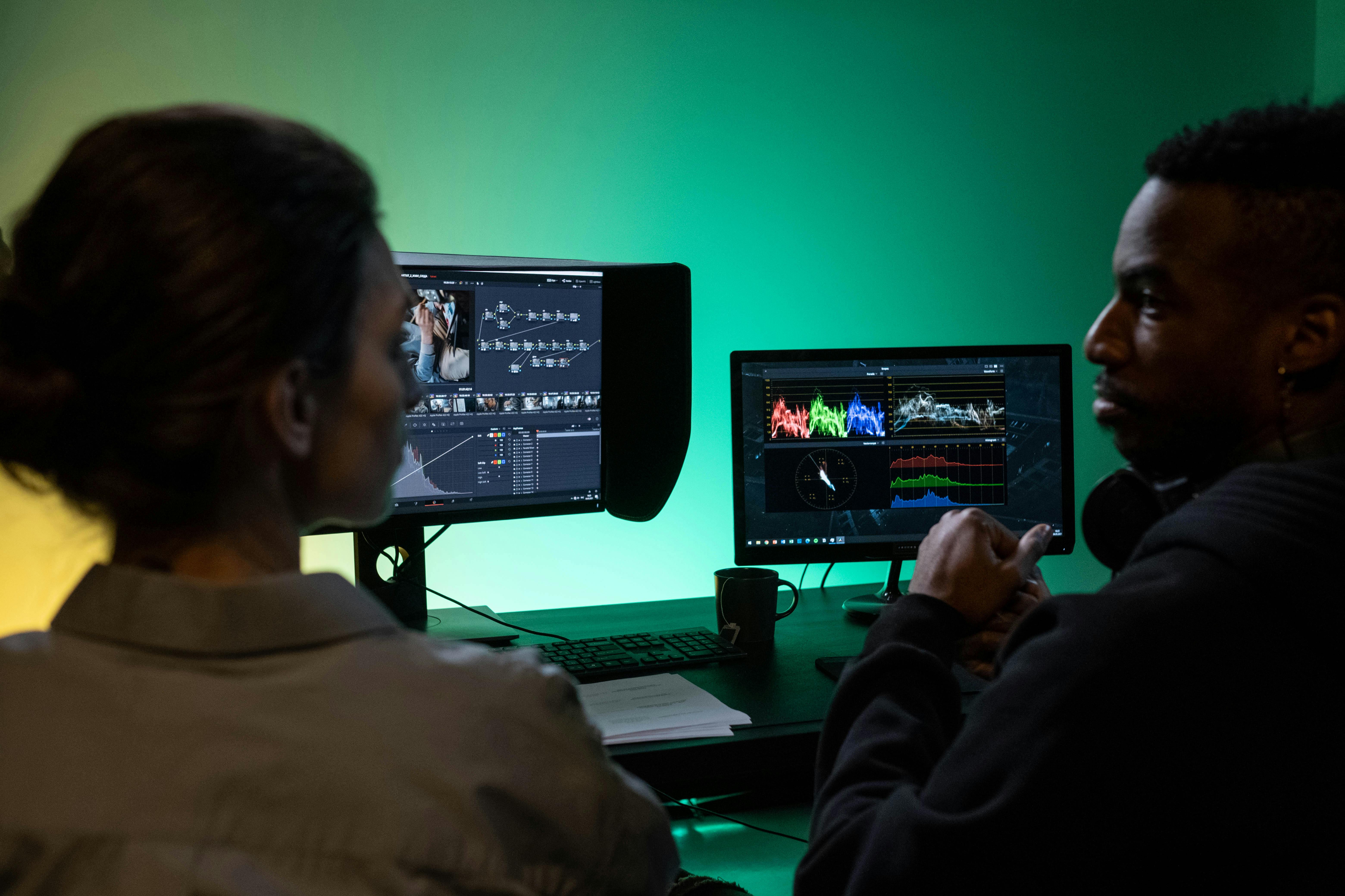 Two editors working in DaVinci Resolve on dual monitors